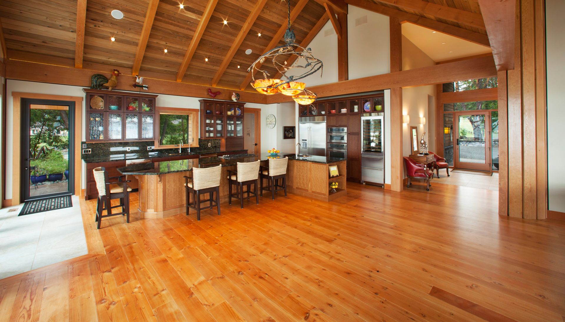 Timber frame great room and kitchen with wood ceilings and floors