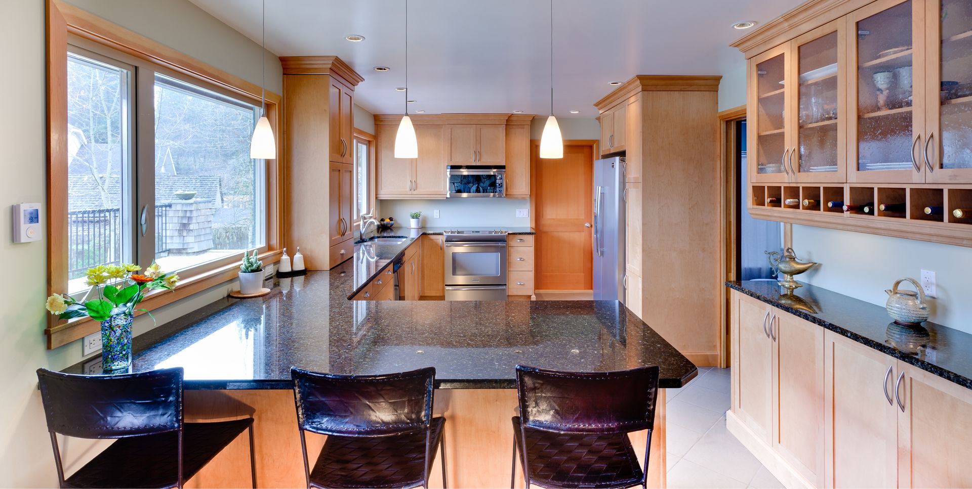Wood kitchen with a breakfast bar and large windows